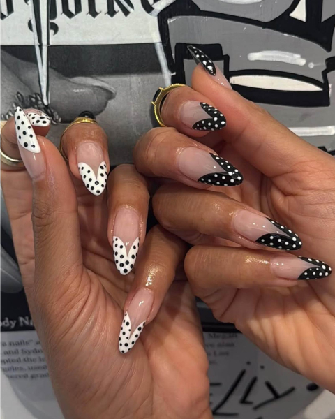Ladybug wingstyle black and white inverse french tip nails with nude base.